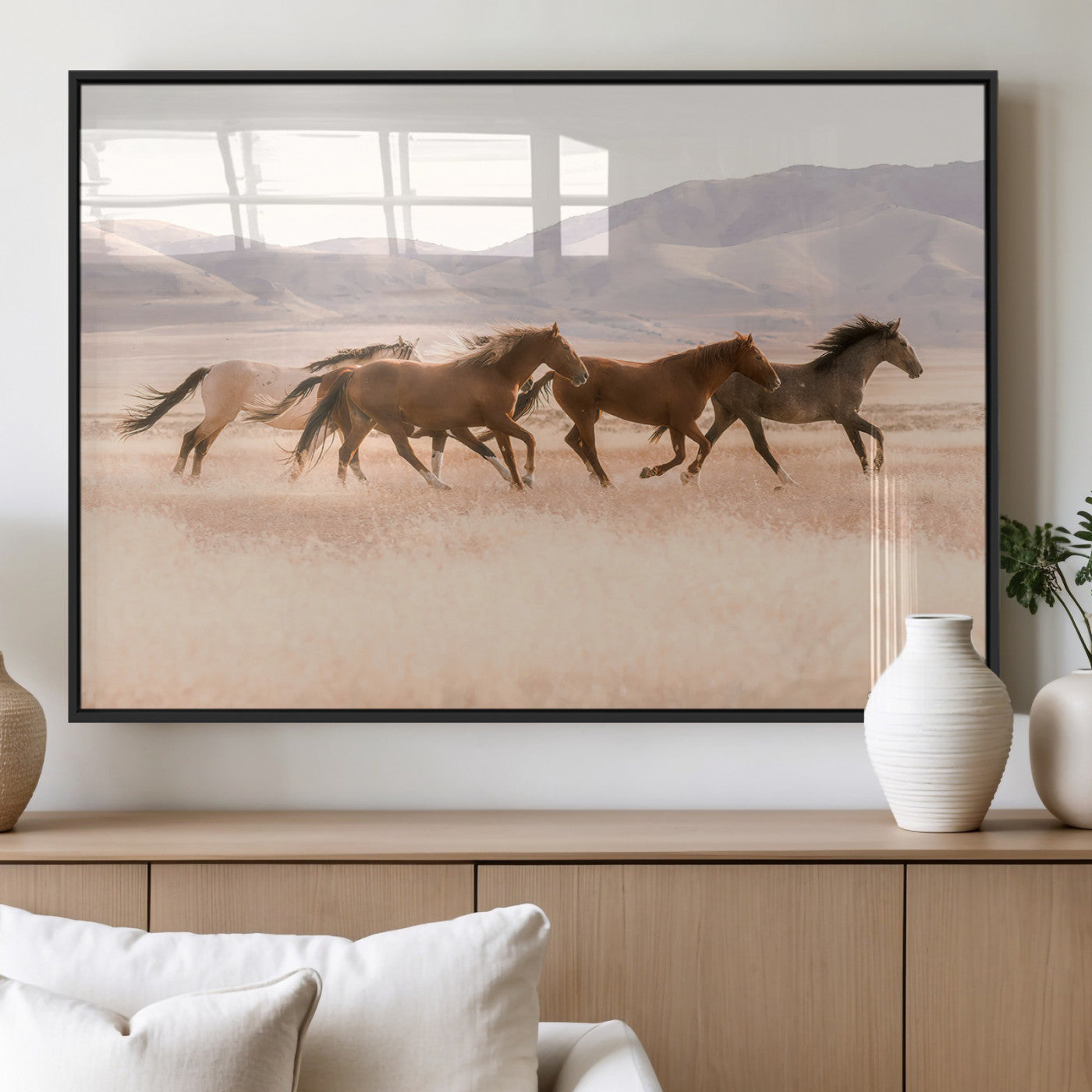 A herd of wild horses galloping through a sunlit desert plain with mountains in the background, perfect for rustic or western-themed wall decor.