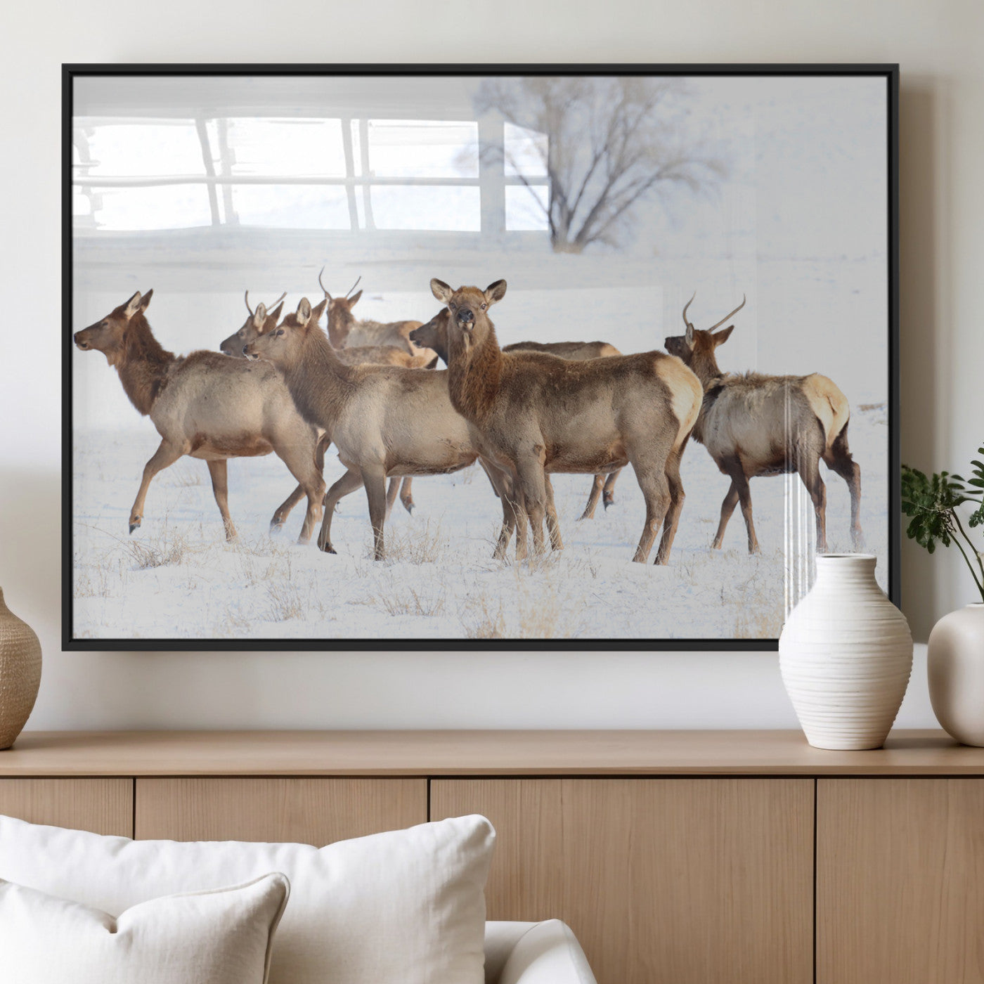 A group of elk standing on snowy terrain with a tree in the background, perfect for rustic or lodge-style winter wall decor.