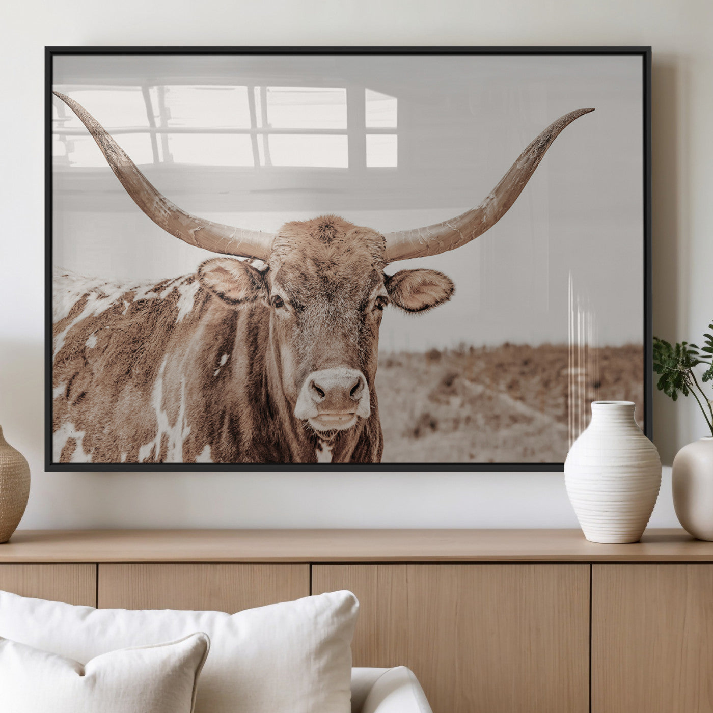 A longhorn cow in soft beige desert tones, standing calmly in open land, perfect for neutral western or rustic farmhouse interiors.