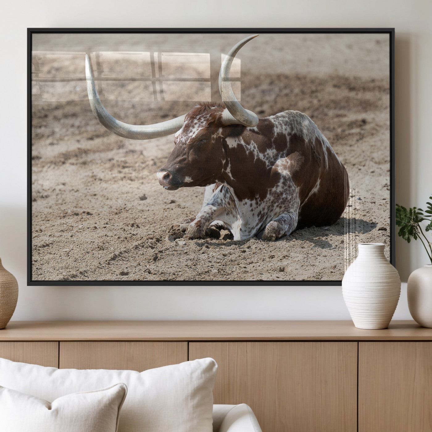 Texas Longhorn resting on sandy ground with large curved horns, capturing a rustic Western aesthetic perfect for farmhouse-style wall art.