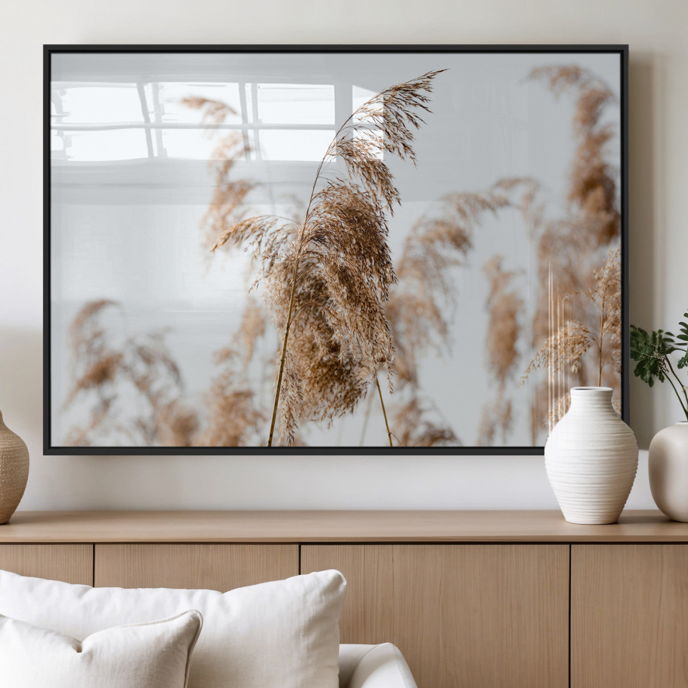 Close-up of pampas grass swaying in the wind against a soft white sky, creating a neutral and minimalist botanical aesthetic.