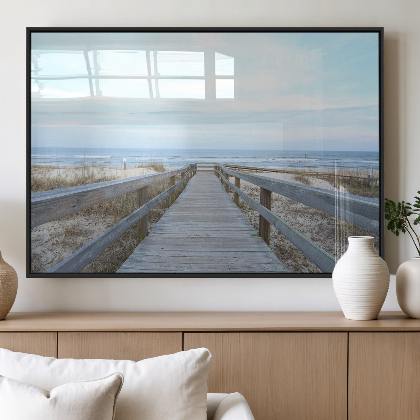 Wooden boardwalk leading to a peaceful beach with gentle ocean waves under a soft pastel sky, perfect for coastal and nautical home decor.