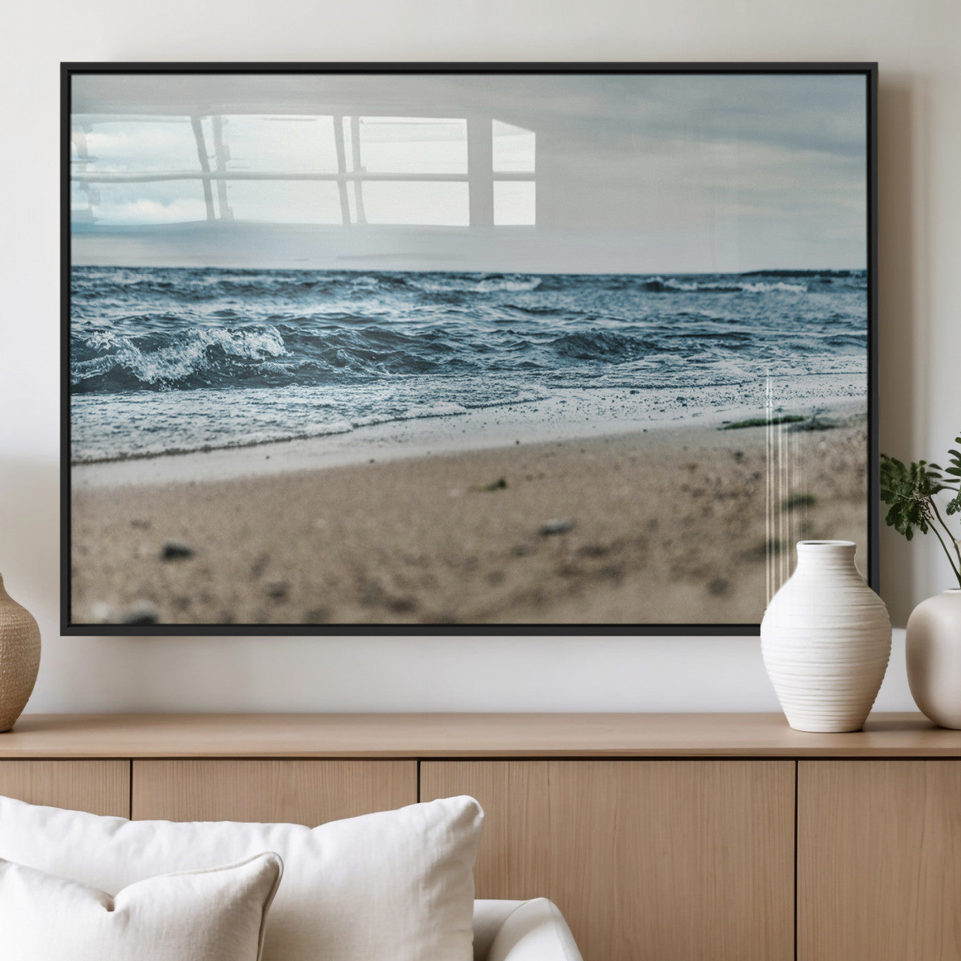 A moody ocean scene with gentle waves washing onto a sandy beach under a cloudy sky, creating a peaceful and coastal atmosphere.