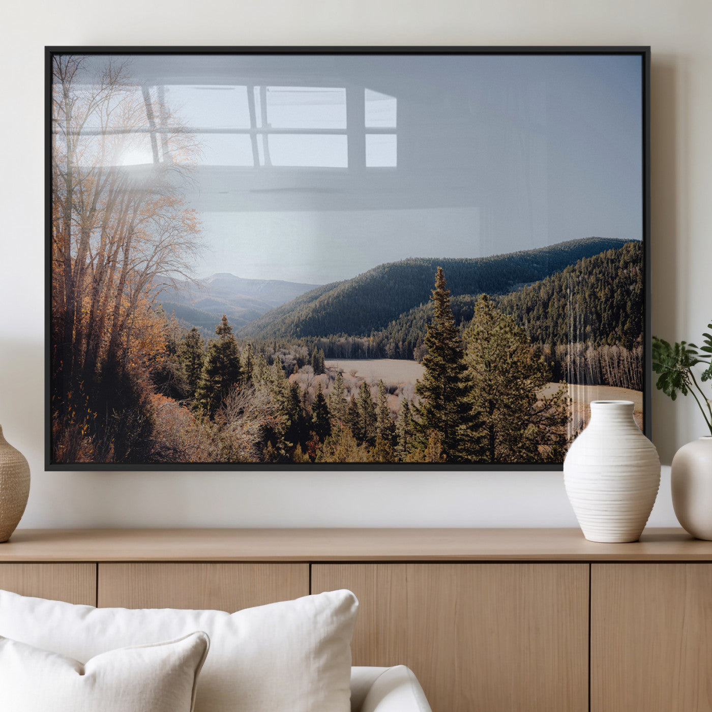 A scenic mountain valley with pine trees and autumn foliage under a clear sky, bathed in golden sunlight, creating a peaceful and rustic landscape.