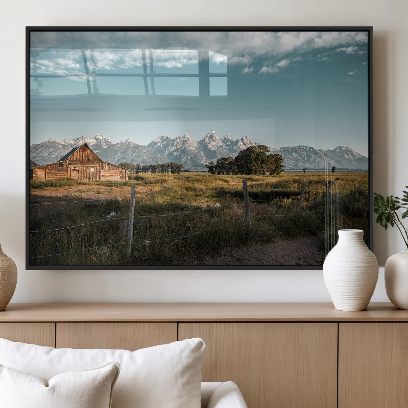 A rustic farmhouse with a wooden barn set against majestic mountain peaks under a soft blue sky, evoking peaceful countryside charm.