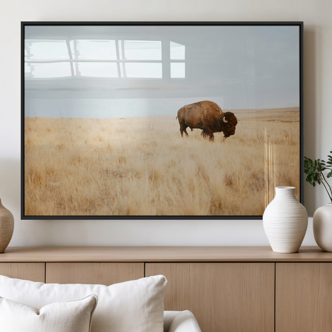 A lone bison standing in a vast golden grassland under a soft blue sky, evoking a rustic and Western aesthetic, ideal for farmhouse decor.