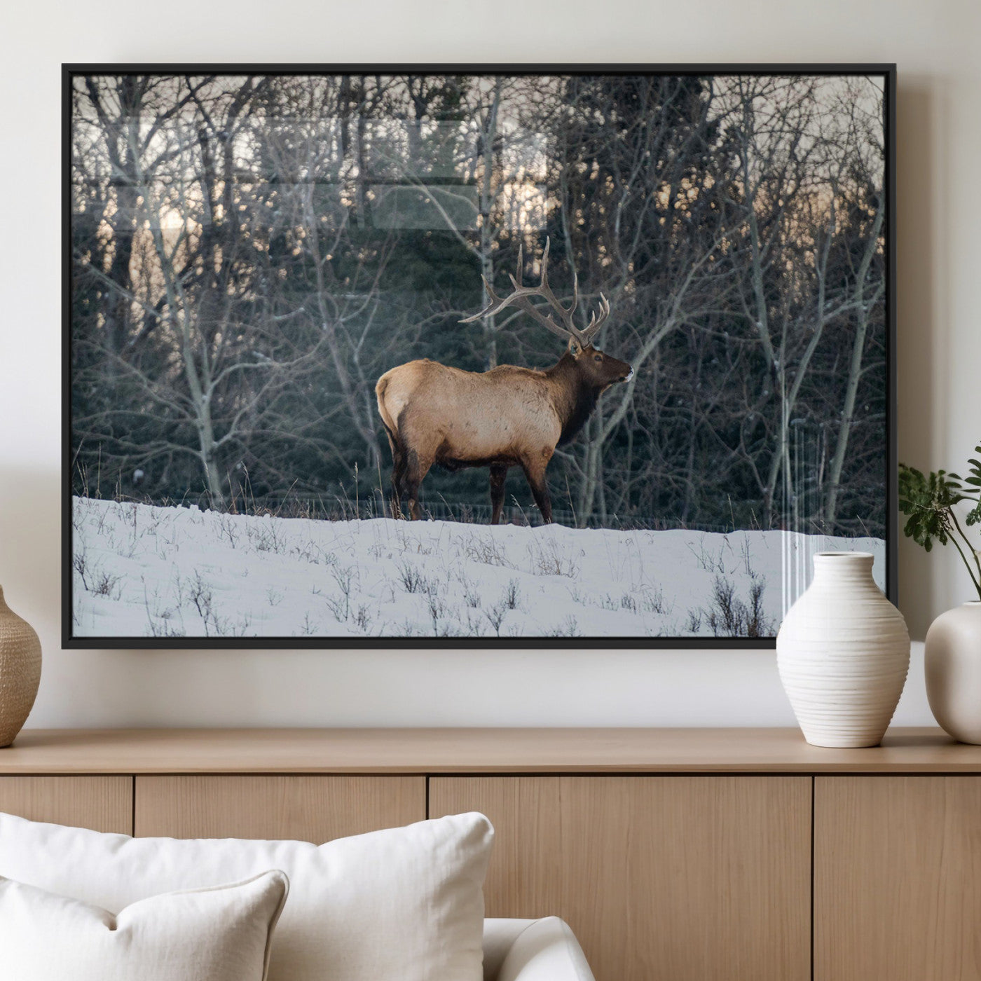 A majestic elk with large antlers standing in a snowy field against a winter forest backdrop, perfect for rustic and wildlife-themed home decor.