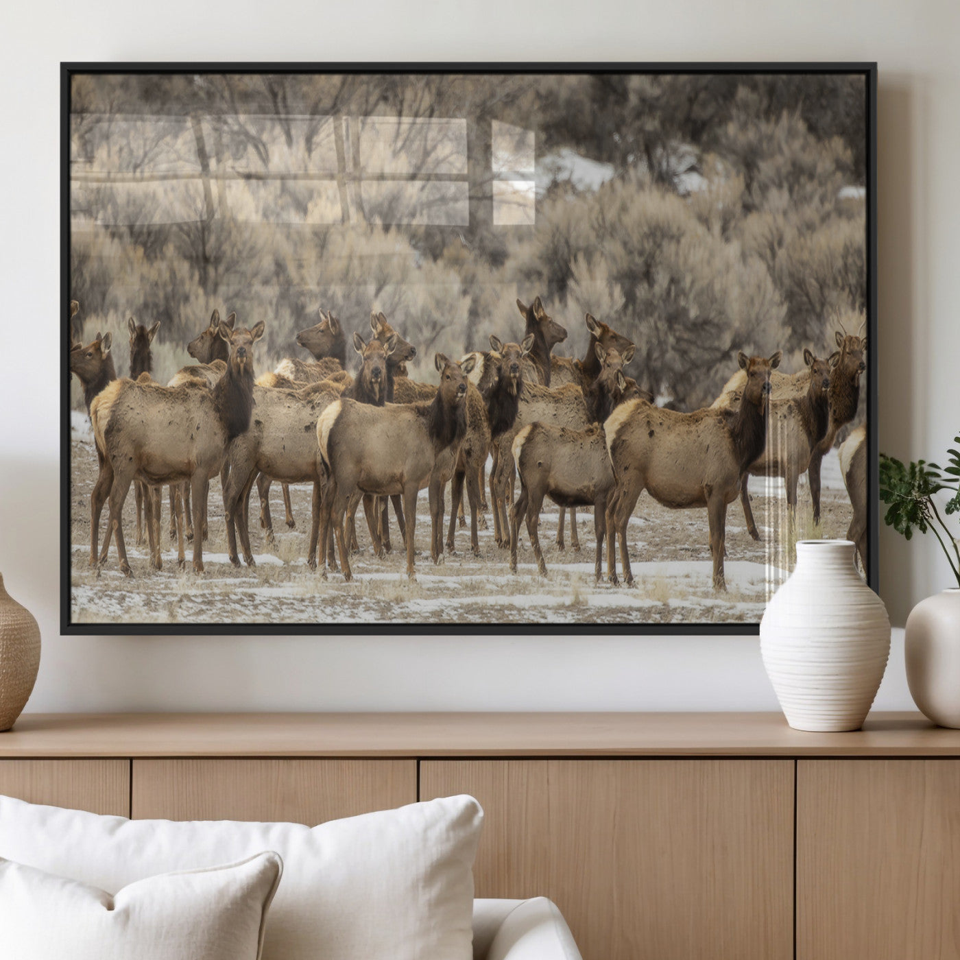 A stunning wall art canvas print featuring a large herd of elk standing together in a natural winter landscape with muted earthy tones and soft background foliage, perfect for rustic or nature-inspired home decor.