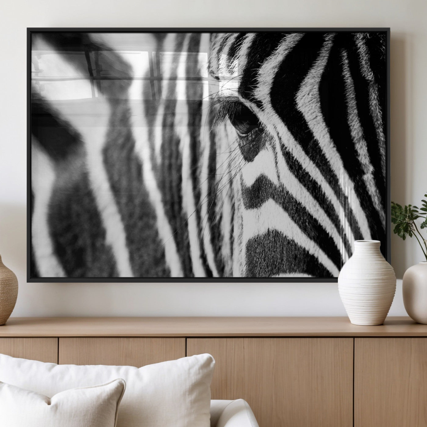 A close-up black and white photograph of a zebra's eye, showcasing the intricate patterns of its stripes in sharp detail.