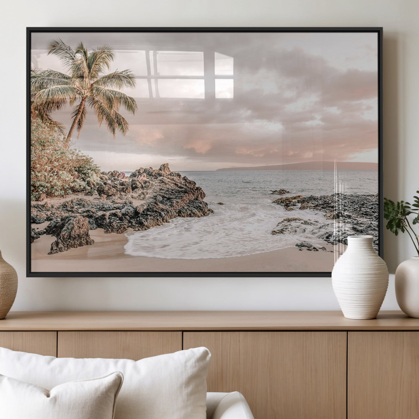 A peaceful beach scene with a palm tree and rocks, soft waves washing onto the shore under a soft pastel sky at sunset.