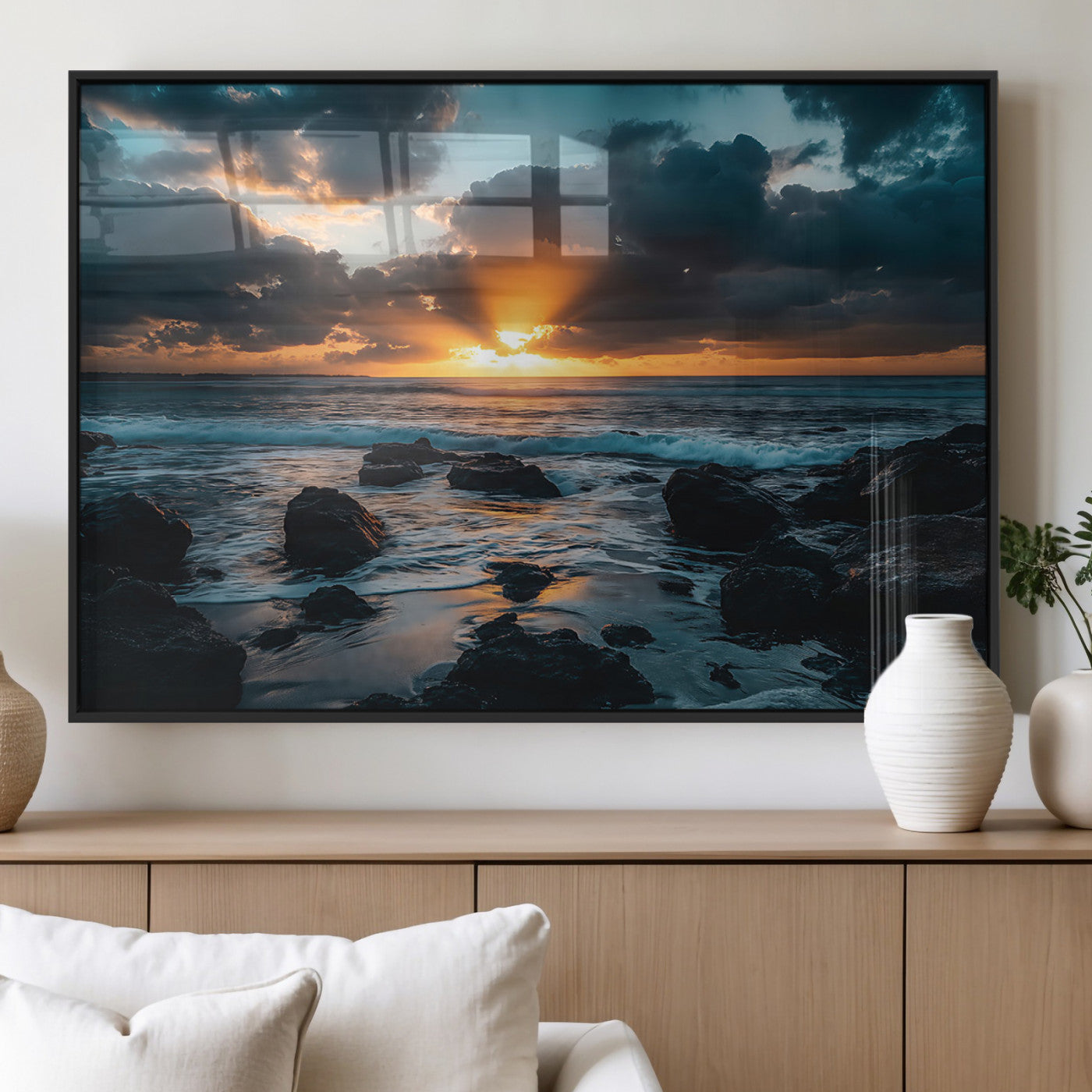 An awe-inspiring sunset over the ocean with rays of light piercing through dramatic clouds, creating a beautiful seascape with rocks in the foreground.