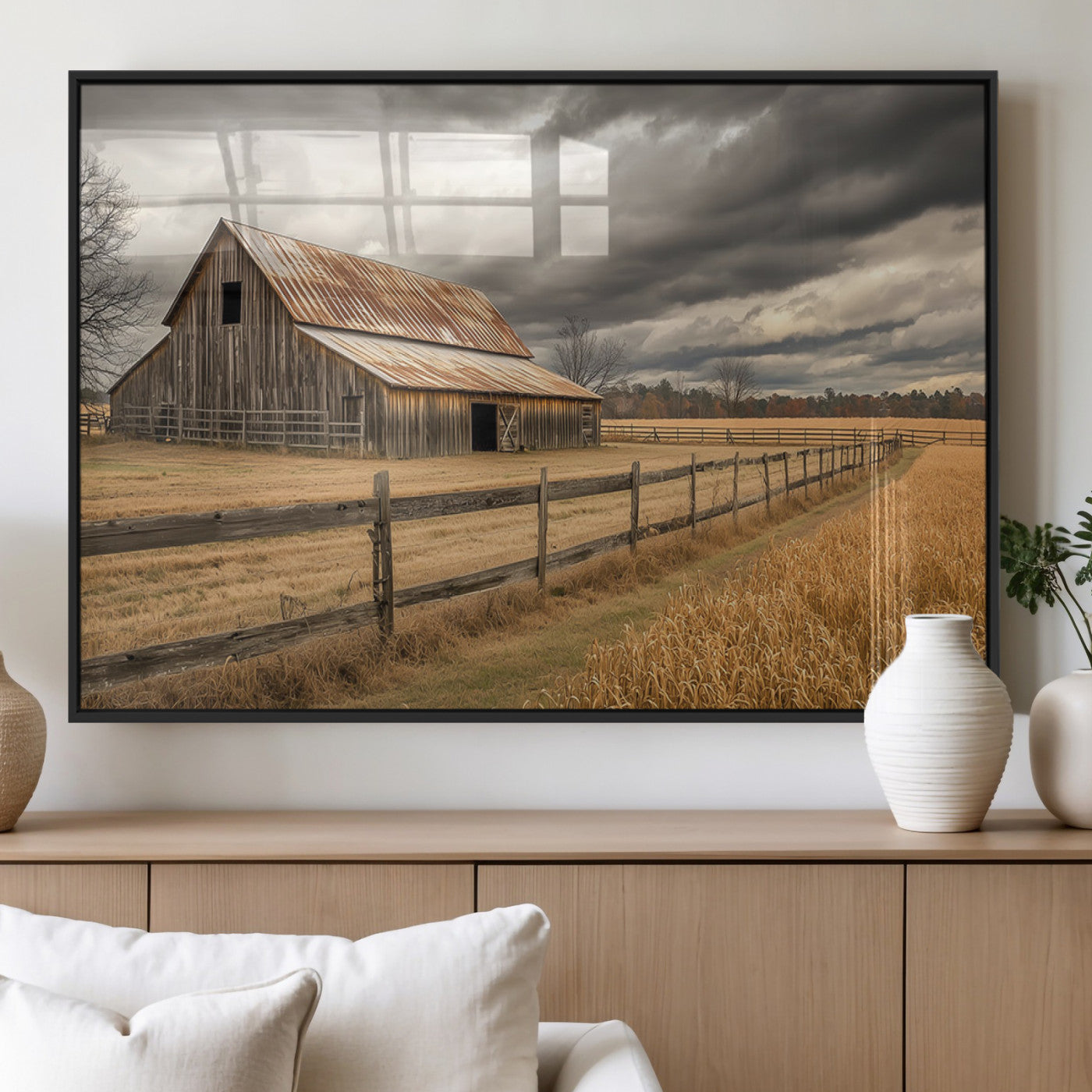 "Rustic barn with a weathered metal roof, surrounded by a wooden fence and golden fields under an overcast sky with dramatic clouds."