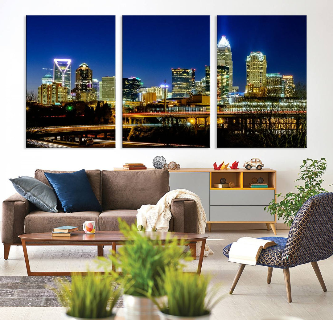 The Charlotte City Lights Night Blue Skyline Cityscape View Wall Art Canvas Print, showcasing an illuminated city skyline at night, is printed on museum-quality canvas with a UV-protective coating. Enhance your space with this stunning piece and enjoy free shipping with your purchase.