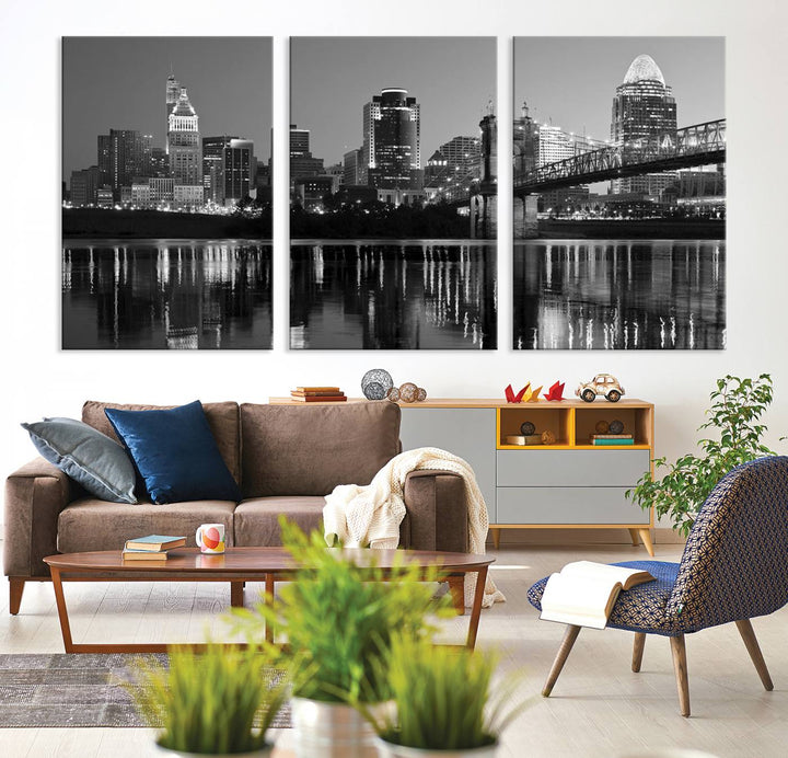 The wall showcases a ready-to-hang triptych of the Cincinnati City Lights Skyline in black and white, printed on museum-quality canvas.