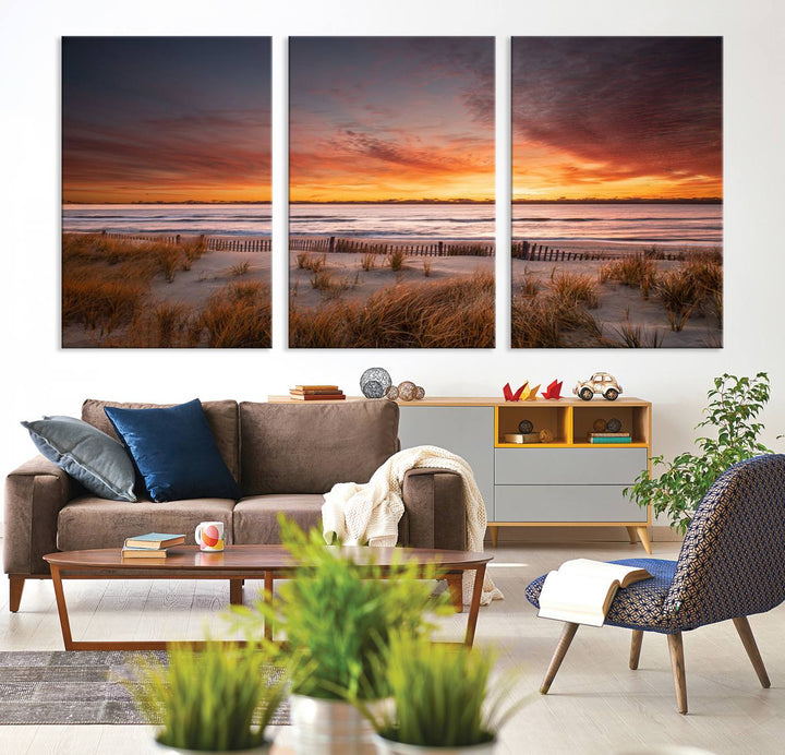 Sunset on The Beach Wall Art Canvas Print features a triptych of a beach at sunset with vivid orange skies, presented on museum-quality canvas. Each section is gallery wrapped, offering lasting beauty with its UV-protective coating.