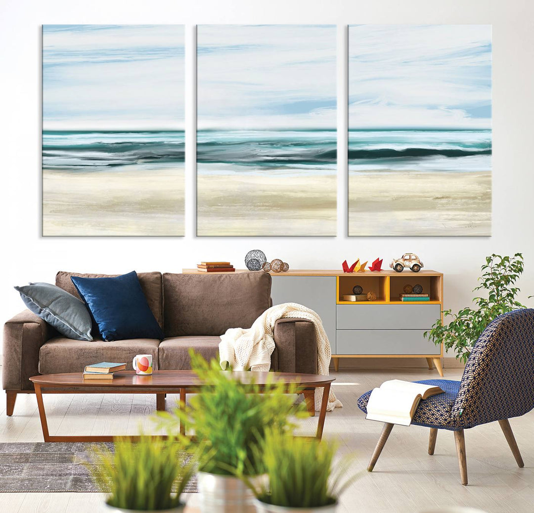 The room features the Ocean Abstract Wall Art Canvas Print, a triptych beach painting on museum-quality canvas with a gallery-wrapped finish and UV-protective coating.