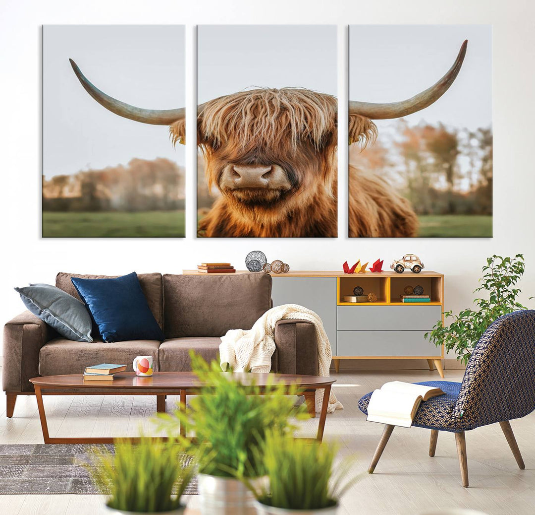 A Highland Cow Animal Scottish Cattle Art Print Farmhouse Wall Art Canvas Print hangs in the living room, adding a touch of rustic farmhouse decor.