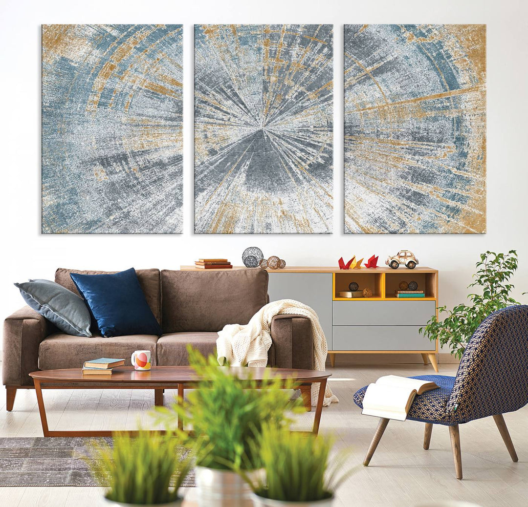 The Radiant Abstract Wood Rings Canvas Art, a modern triptych wall decor, enhances the contemporary style of the living room with its blue, white, and gold hues.