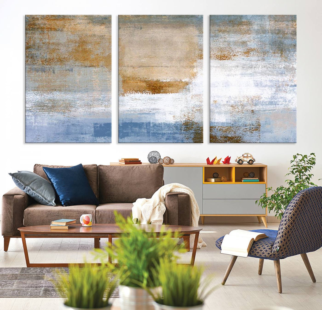 The Blue Multi Panel Abstract Wall Art Canvas Print, featuring an elegant blend of blue, beige, and brown tones, hangs gracefully on the wall, adding a contemporary touch to the space.