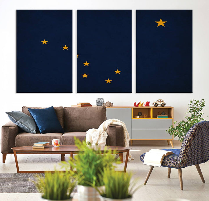 A contemporary living room featuring a triptych artwork of stars on a navy background, accentuated by the striking Alaska States Flag Wall Art Canvas Print.