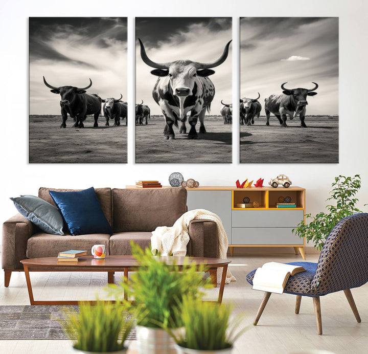 The Black and White Longhorn Cattle Wall Art, featuring a three-panel display of cowboy Western longhorns walking toward the viewer, enhances your space with its striking presence, adding a touch of Western decor.