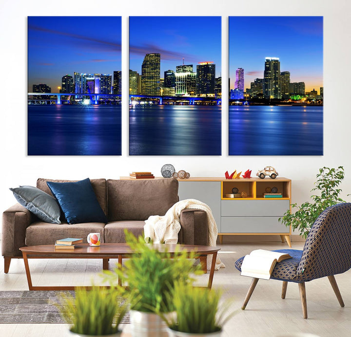 The modern living room showcases a striking Miami Blue Night Wall Art canvas print on the wall. The artwork is gallery wrapped on museum-quality canvas, ensuring durability and elegance.