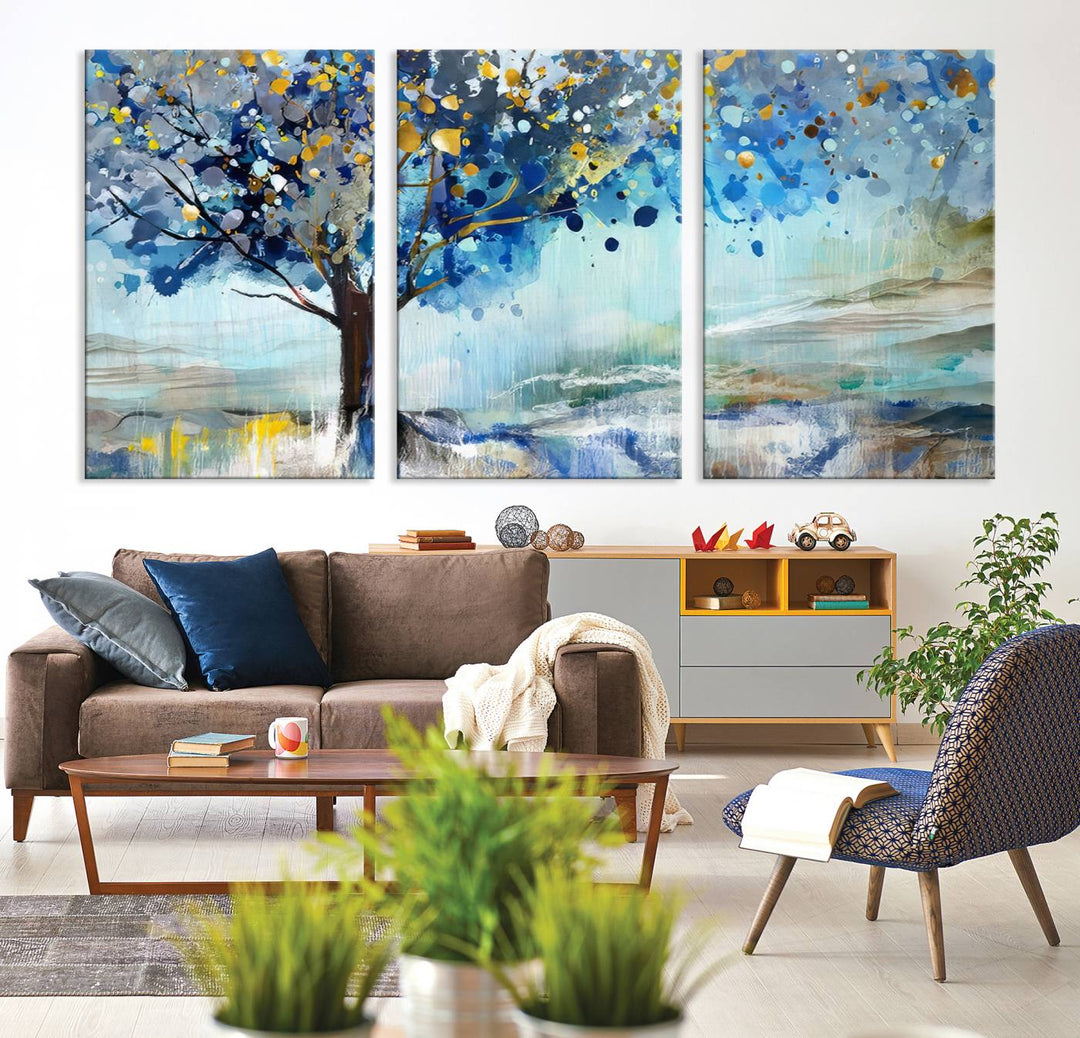 A modern living room features a three-panel Watercolor Style Abstract Tree Printing Wall Art Canvas in vibrant blue and yellow, crafted on museum-quality material.