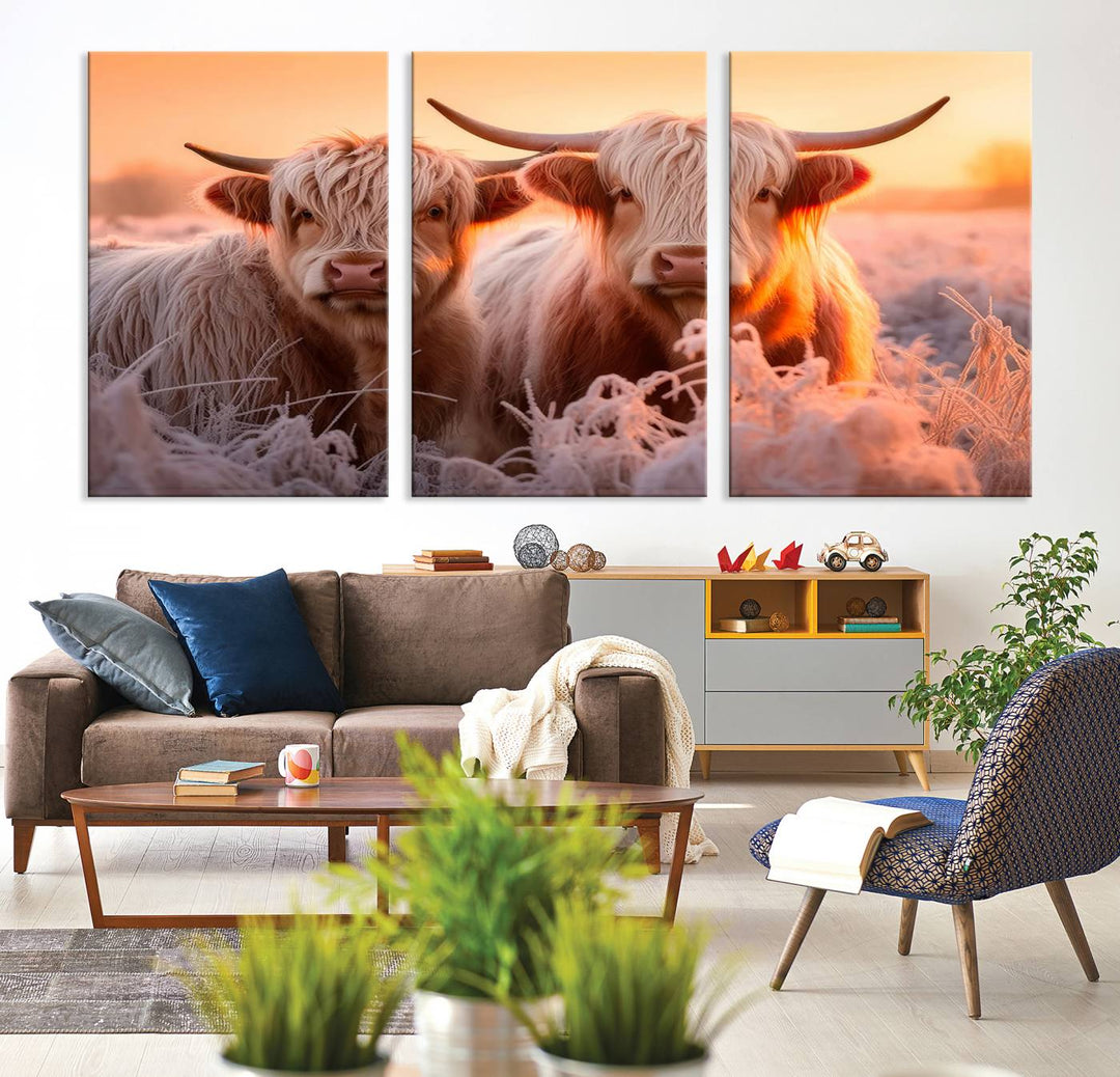 The "Highland Cows at Sunrise Wall Art Canvas Set" beautifully captures a serene and rustic farmhouse aesthetic, portraying two Highland cows in a frosty landscape at sunrise.