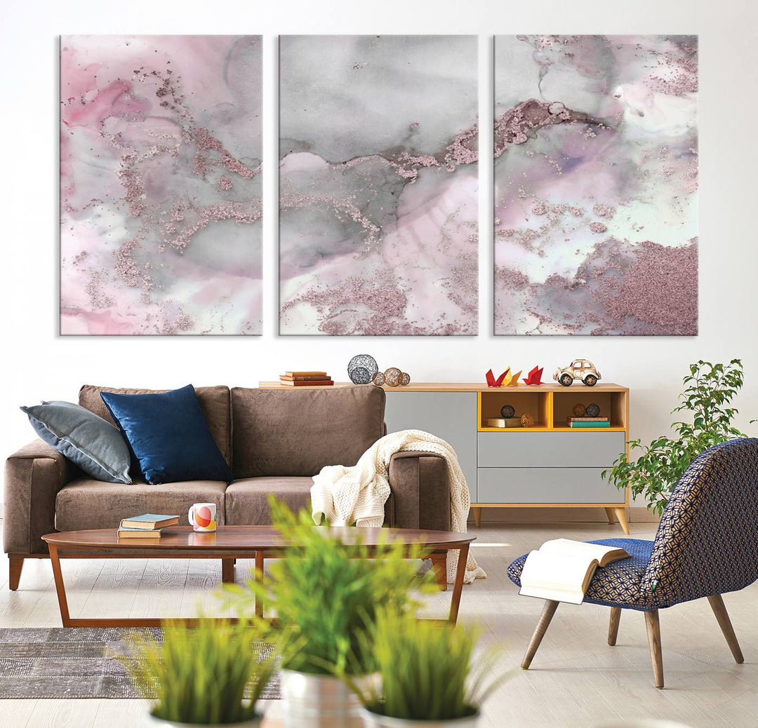 The Rose Marble Abstract Wall Art Canvas Print is a stunning triptych that showcases pink and gray tones, elegantly presented on a dark wall.