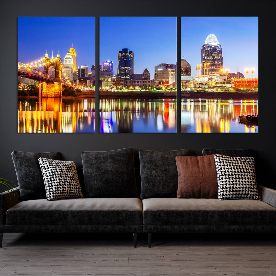 The "Cincinnati City Lights Night Skyline Cityscape View Wall Art Canvas Print" is a gallery-wrapped, museum-quality canvas illustrating a lit-up bridge and skyline at night. Enhanced with a UV-protective coating, this piece ensures lasting vibrancy.