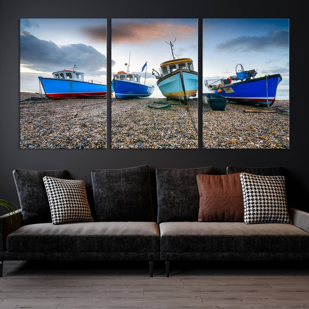 The "Big Boats On The Beach Wall Art Canvas Print" is a stunning piece featuring three museum-quality panels depicting fishing boats on a pebbled shore. Ready to hang and featuring UV-protective coating, it serves as an elegant addition to your home décor.