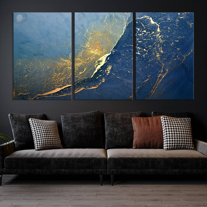 The Navy Blue Yellow Twinkle Wall Art Canvas Print, featuring an abstract design in gold and blue, enhances a modern living room as it adorns a white wall with its gallery-wrapped, museum-quality canvases for an exquisite touch.