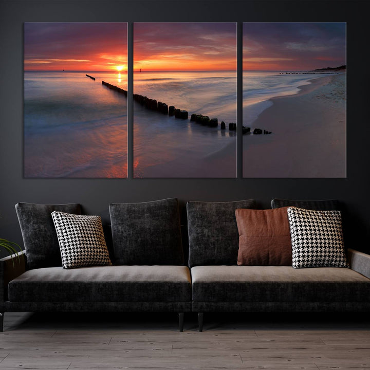 In a modern living room, the Sunset Beach Wall Art Canvas Print is displayed above. This triptych, printed on museum-quality canvas with a UV-protective coating, ensures lasting brilliance. It's ready to hang and brings an elegant touch to your space.