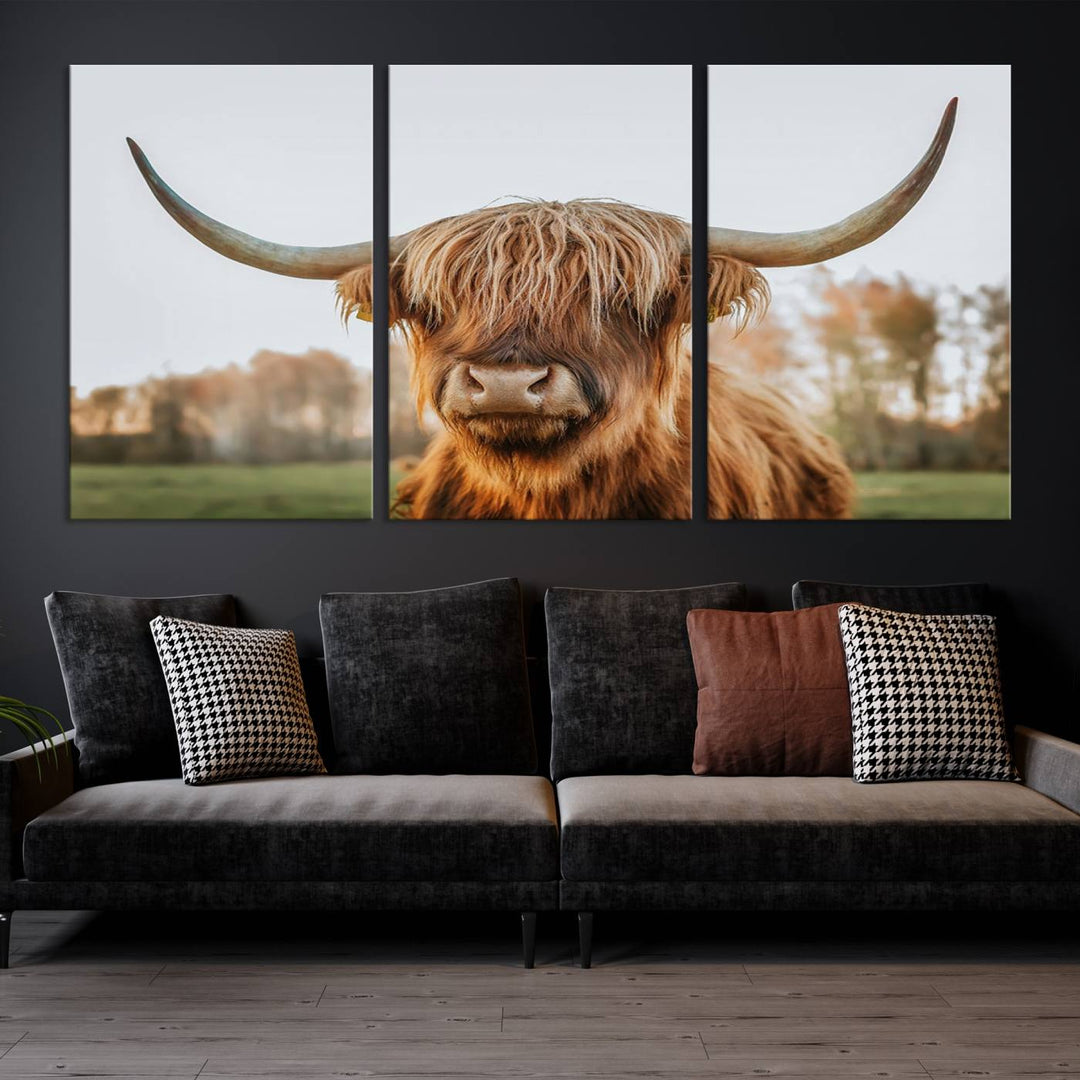 A Highland Cow Animal Scottish Cattle Art Print Farmhouse Wall Art Canvas Print hangs in the living room, adding a touch of rustic farmhouse decor.