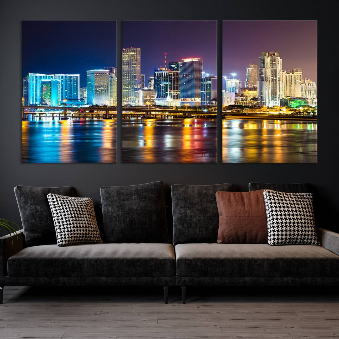 The Wall Art MIAMI Canvas Print features a stunning triptych of a city skyline at night, with vibrant lights reflecting on the water. This gallery-wrapped piece on museum-quality canvas delivers an exquisite finish.