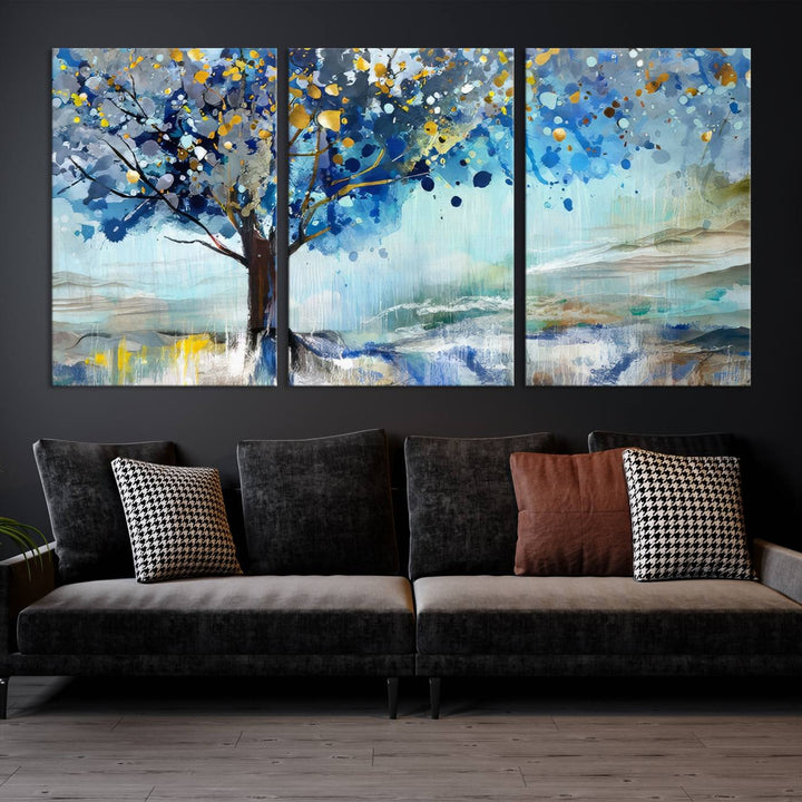 A modern living room features a three-panel Watercolor Style Abstract Tree Printing Wall Art Canvas in vibrant blue and yellow, crafted on museum-quality material.