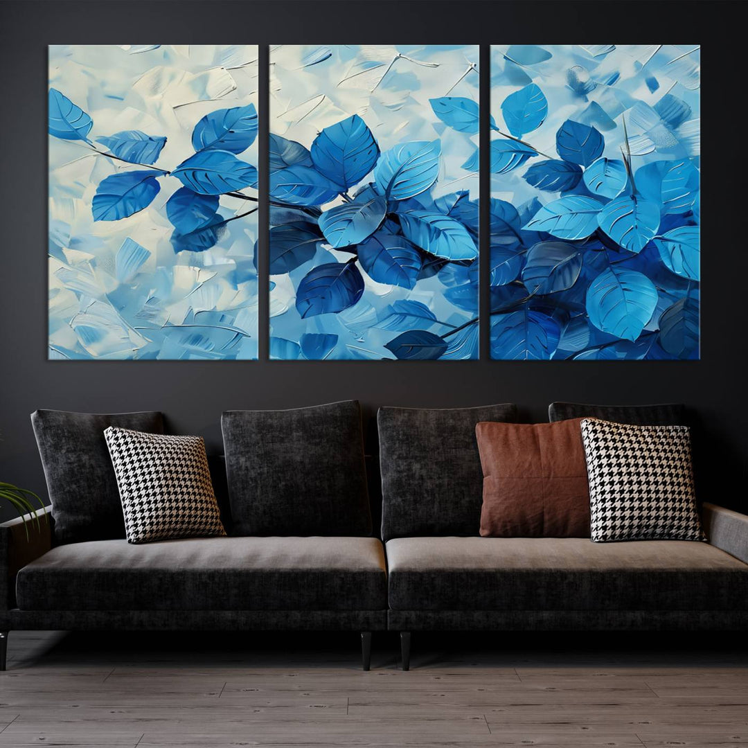 The contemporary living room is highlighted by the Abstract Blue Leaf Wall Art Canvas Print on the wall. The hand-assembled framed art enhances the room's vibrant decor, crafting a gallery-worthy ambience.