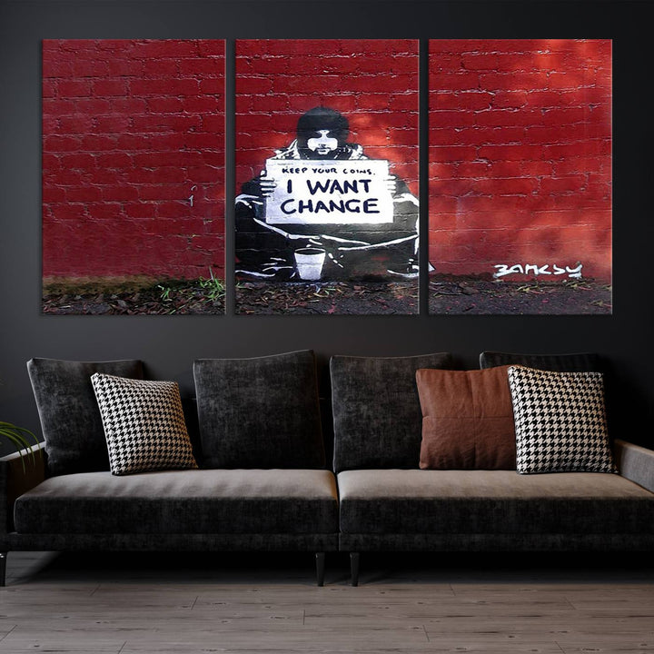 The living room showcases a triptych of stencil artwork on museum-quality canvas, featuring the Banksy I Want Change Graffiti Abstract Wall Art Canvas Print. This captivating piece depicts a person holding a sign that says "I want change" and is finished with a UV-protective coating to ensure long-lasting beauty.