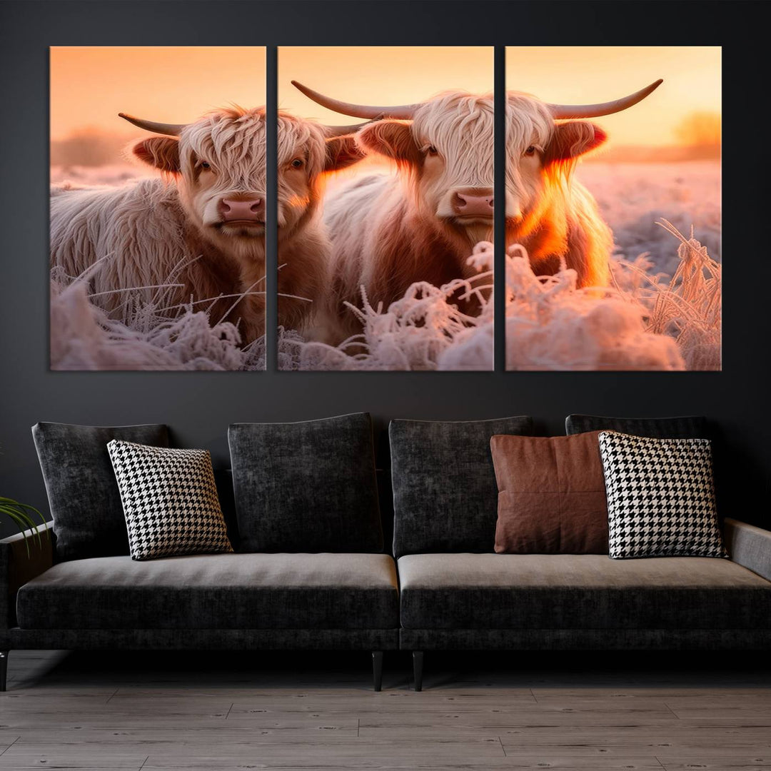 The "Highland Cows at Sunrise Wall Art Canvas Set" beautifully captures a serene and rustic farmhouse aesthetic, portraying two Highland cows in a frosty landscape at sunrise.