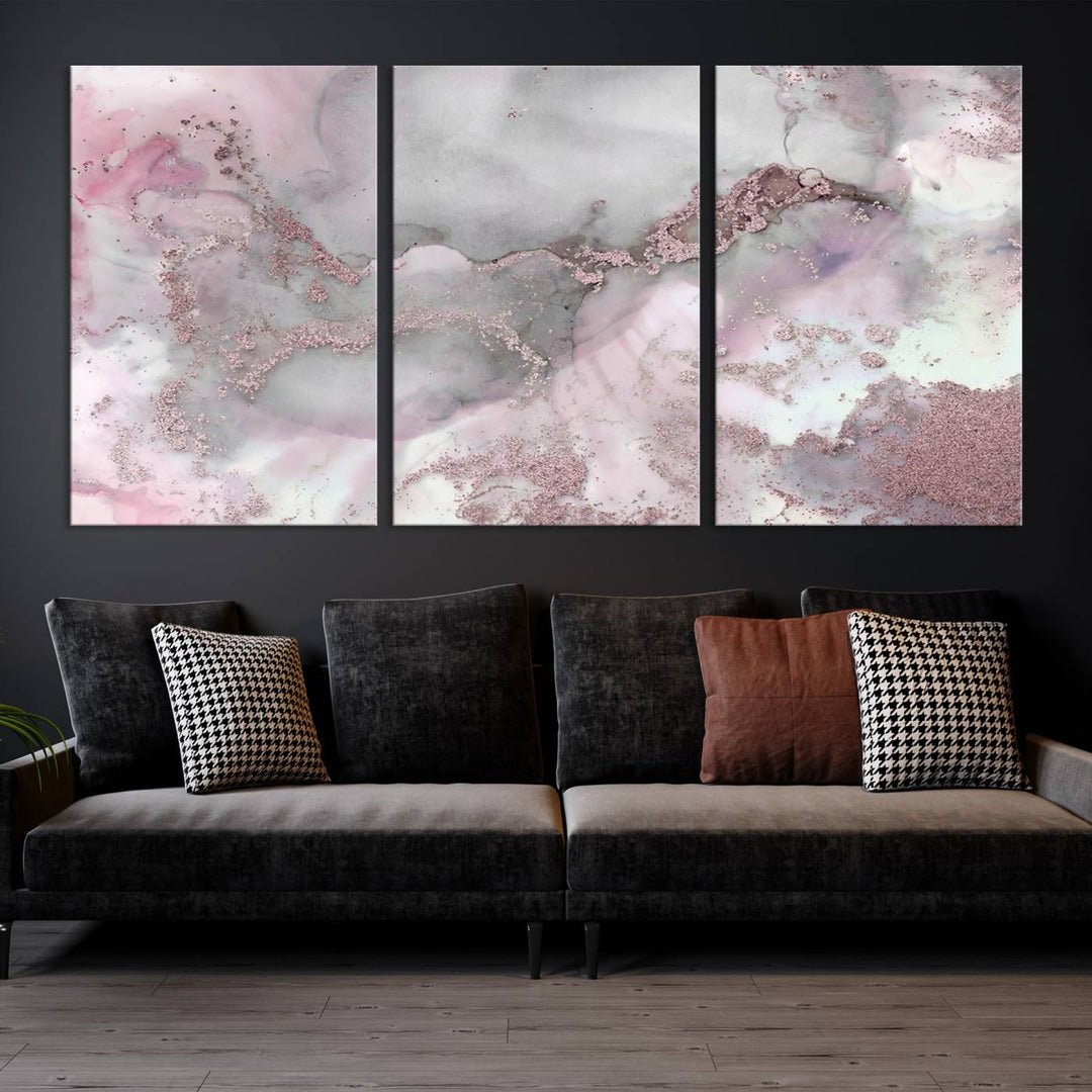 The Rose Marble Abstract Wall Art Canvas Print is a stunning triptych that showcases pink and gray tones, elegantly presented on a dark wall.