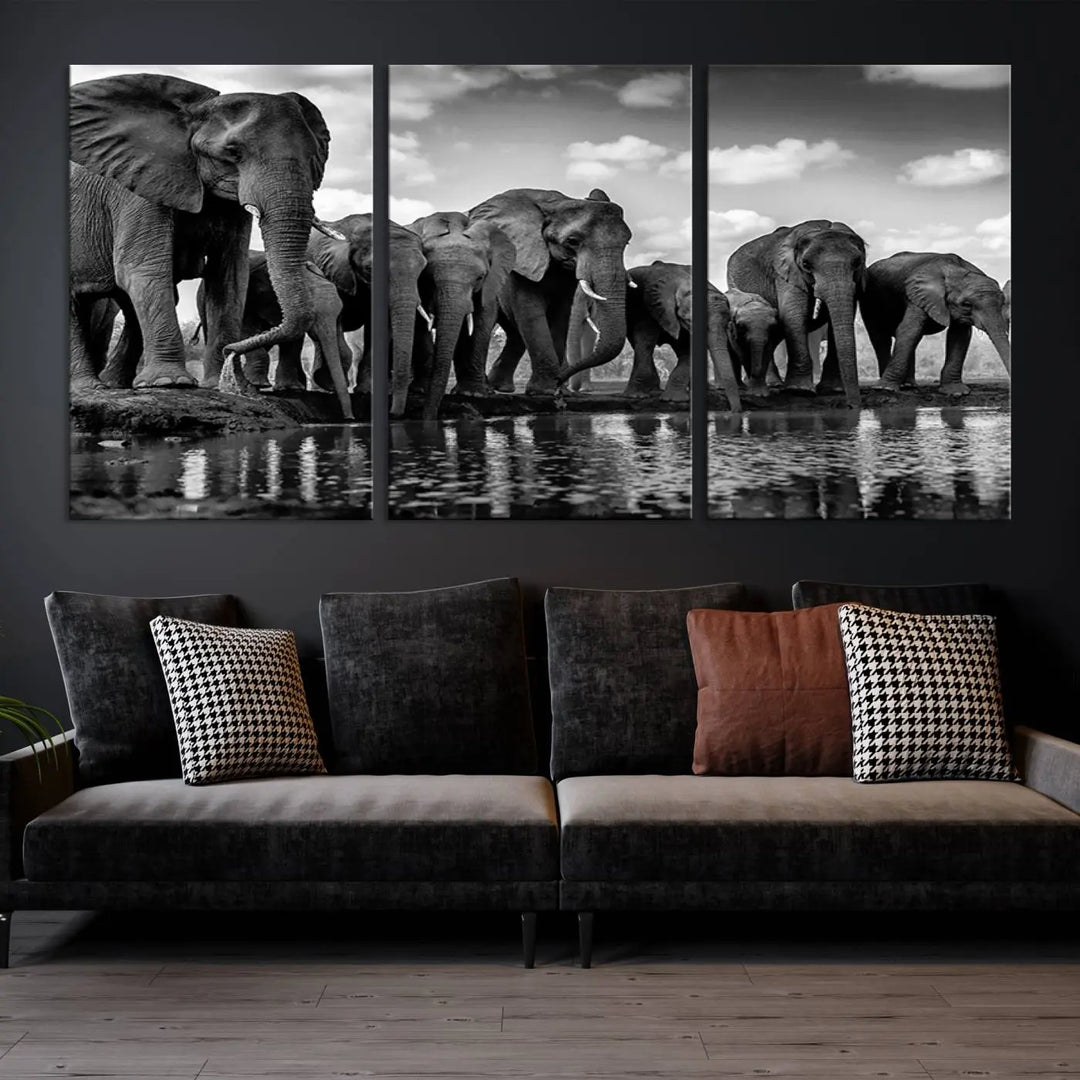 A stunning "Wall Art Animal Canvas Print" featuring a black and white photo of a herd of elephants drinking water is elegantly displayed, gallery wrapped on museum-quality canvas.