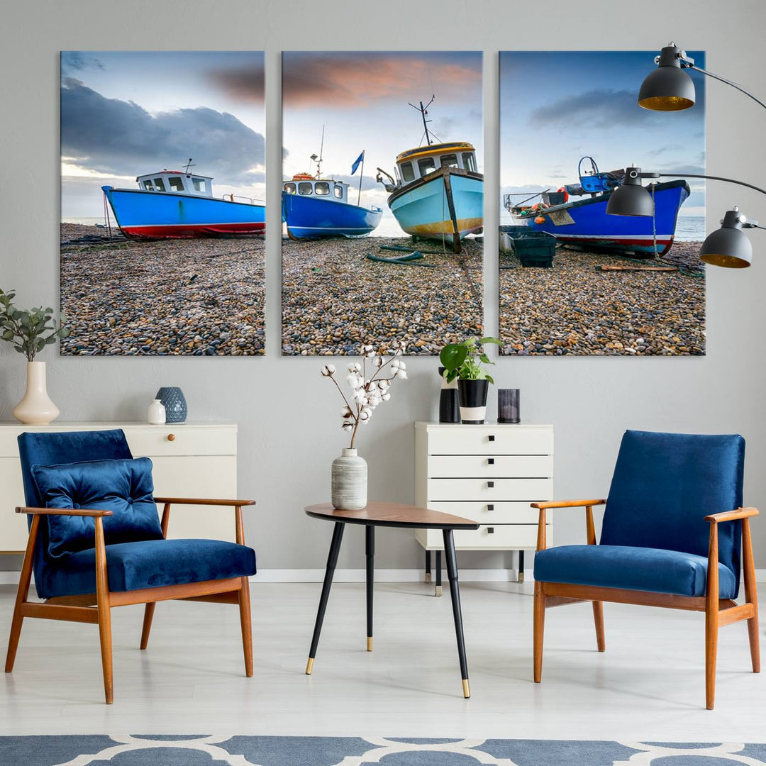 The "Big Boats On The Beach Wall Art Canvas Print" is a stunning piece featuring three museum-quality panels depicting fishing boats on a pebbled shore. Ready to hang and featuring UV-protective coating, it serves as an elegant addition to your home décor.