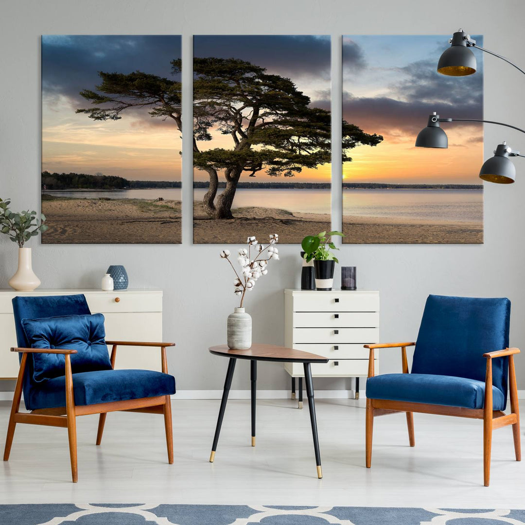 The room showcases the Coastal Sunset Wall Art Canvas Print, a triptych elegantly displayed on museum-quality polycotton canvas, depicting a serene beach sunset with a tree.