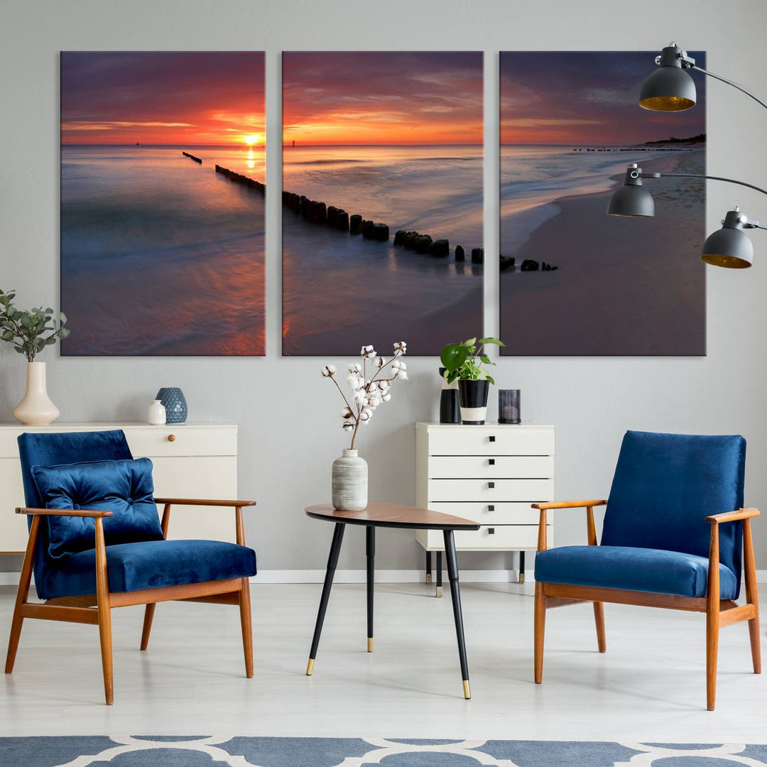 In a modern living room, the Sunset Beach Wall Art Canvas Print is displayed above. This triptych, printed on museum-quality canvas with a UV-protective coating, ensures lasting brilliance. It's ready to hang and brings an elegant touch to your space.