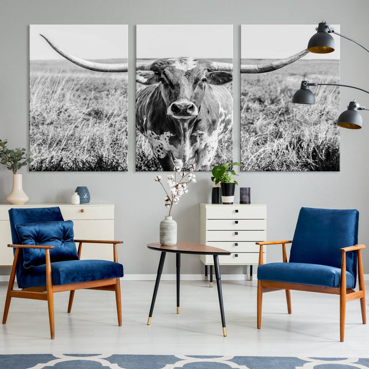 The Texas Cow Longhorn Wall Art Canvas Print is a black and white triptych depicting a cow in a field. It is crafted with museum-quality canvas and features a UV-protective coating.