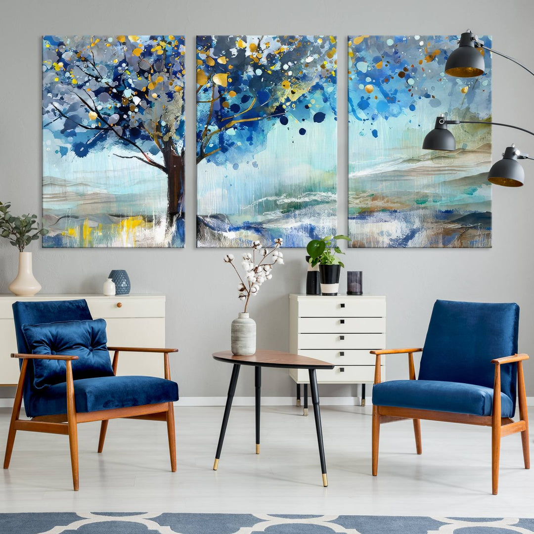 A modern living room features a three-panel Watercolor Style Abstract Tree Printing Wall Art Canvas in vibrant blue and yellow, crafted on museum-quality material.