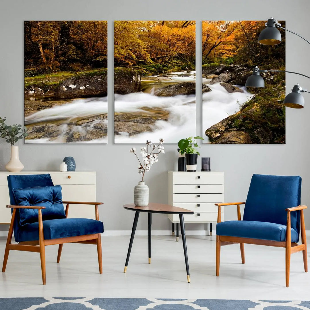 The living room is adorned with the "Wall Art Waterfall Canvas Print River in Forest in Autumn," a triptych on museum-quality canvas showcasing a flowing river surrounded by autumn trees. This ready-to-hang artwork features a UV-protective coating to ensure enduring vibrancy.