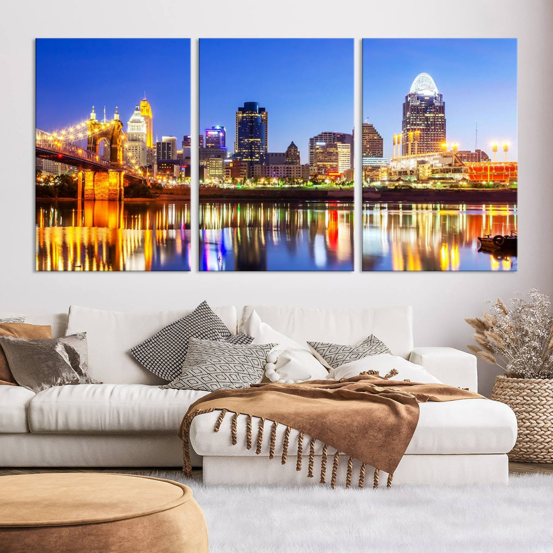 The "Cincinnati City Lights Night Skyline Cityscape View Wall Art Canvas Print" is a gallery-wrapped, museum-quality canvas illustrating a lit-up bridge and skyline at night. Enhanced with a UV-protective coating, this piece ensures lasting vibrancy.