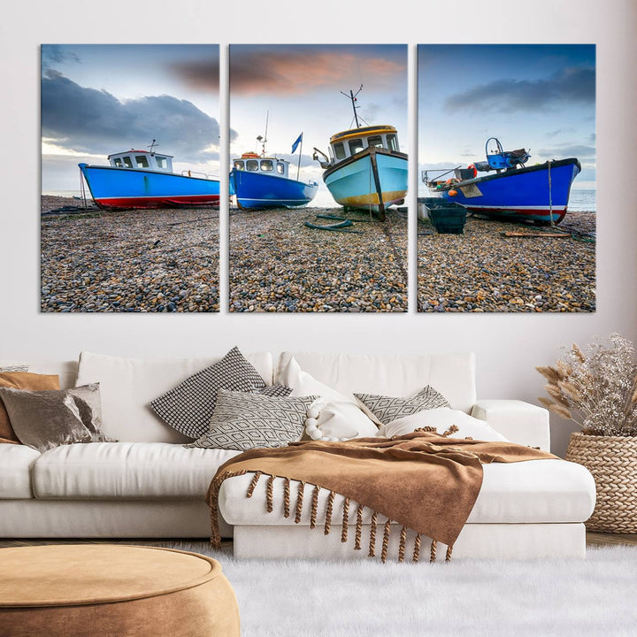 The "Big Boats On The Beach Wall Art Canvas Print" is a stunning piece featuring three museum-quality panels depicting fishing boats on a pebbled shore. Ready to hang and featuring UV-protective coating, it serves as an elegant addition to your home décor.