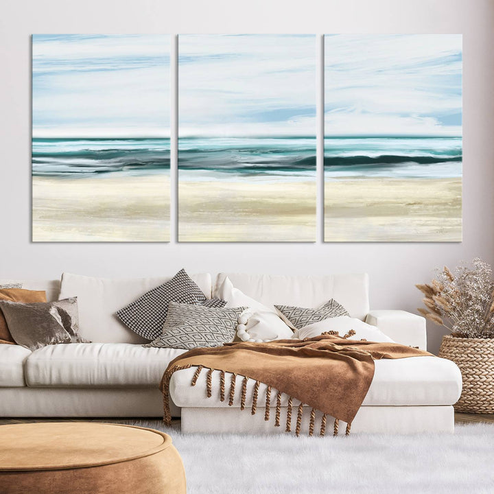 The room features the Ocean Abstract Wall Art Canvas Print, a triptych beach painting on museum-quality canvas with a gallery-wrapped finish and UV-protective coating.